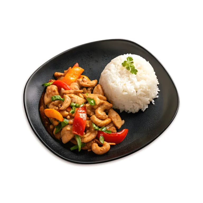Stir-fried chicken with cashew nuts, bell peppers, and scallions served with jasmine rice on a black plate