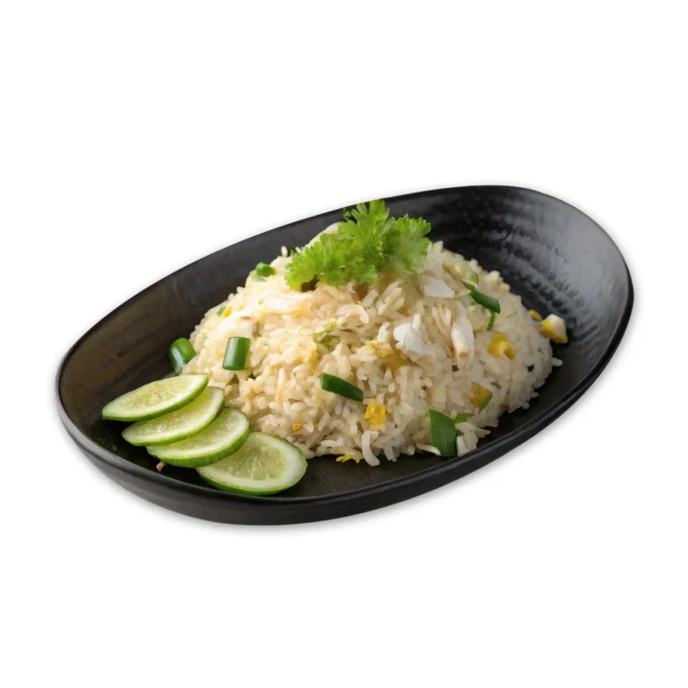 Thai-style crab fried rice served with sliced lime and garnished with fresh herbs on a black plate