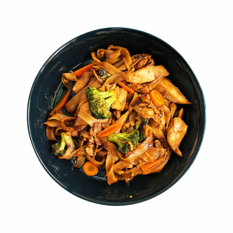 Thai stir-fried flat noodles with chicken, broccoli, carrots, and savory soy sauce in a black bowl